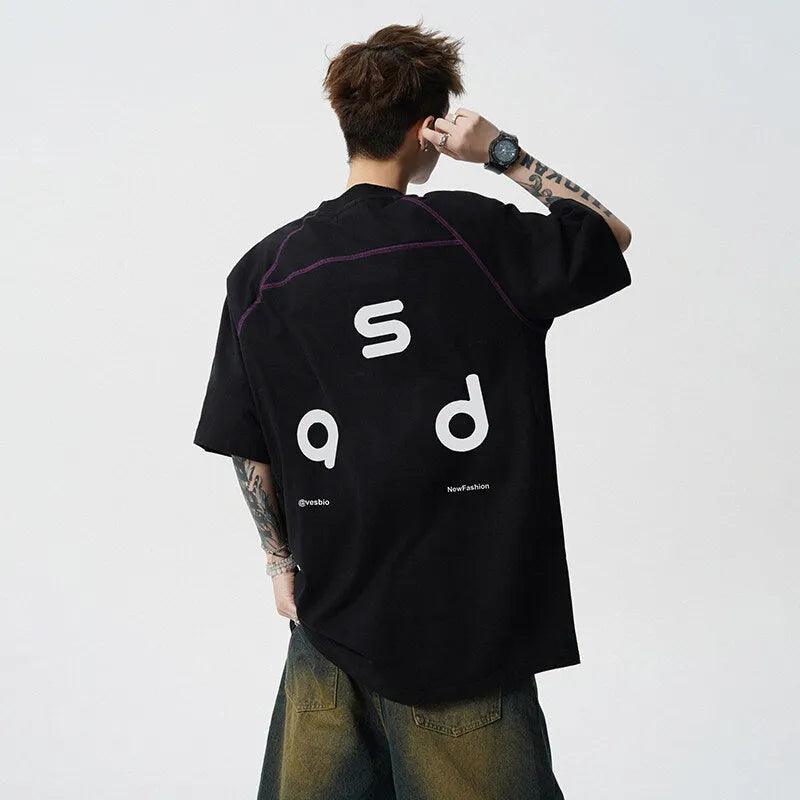 Man wearing a loose-fitting black cotton T-shirt with a white letter print on the chest.