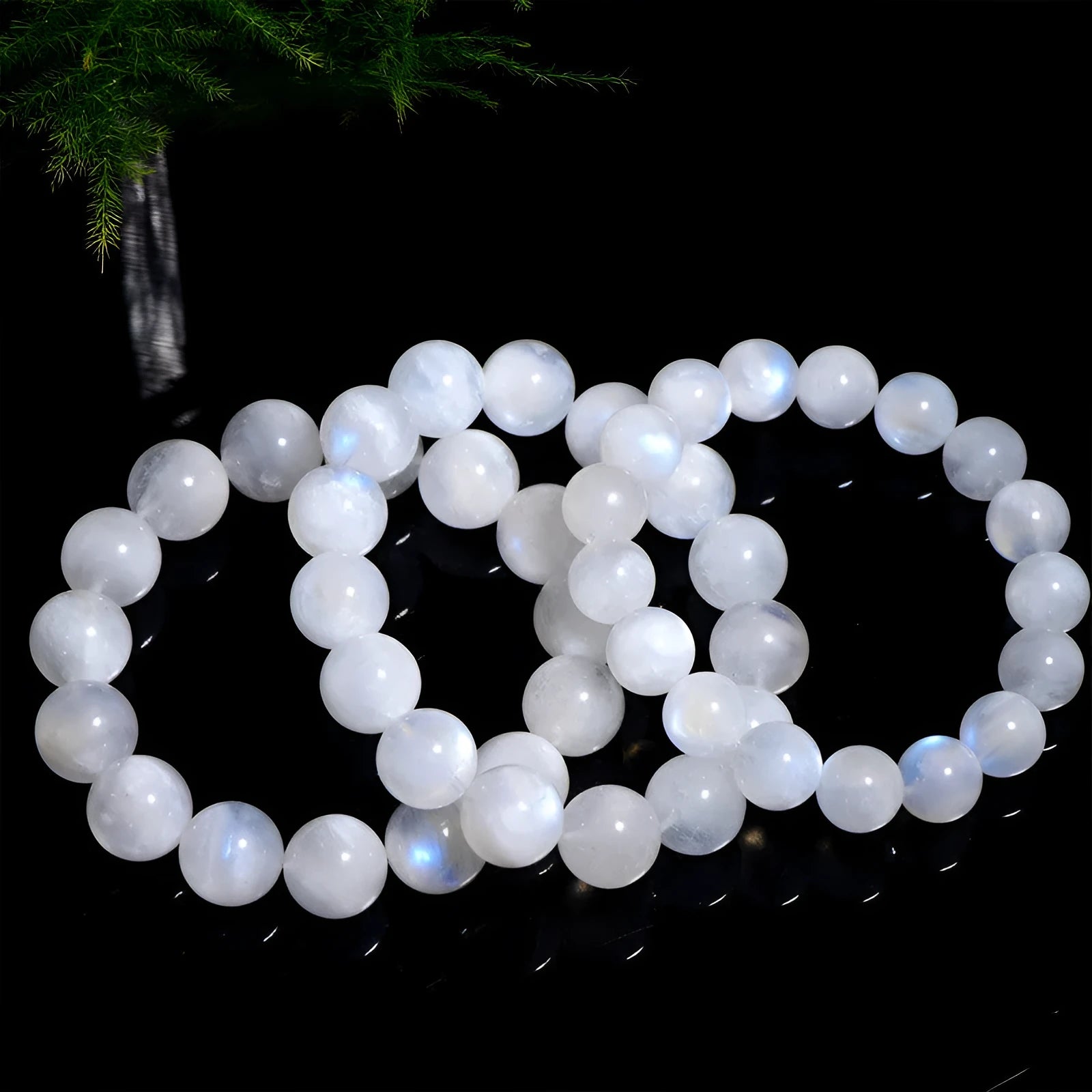 Natural blue moonlight round bead moonstone bracelet on a wrist, showing polished stones.