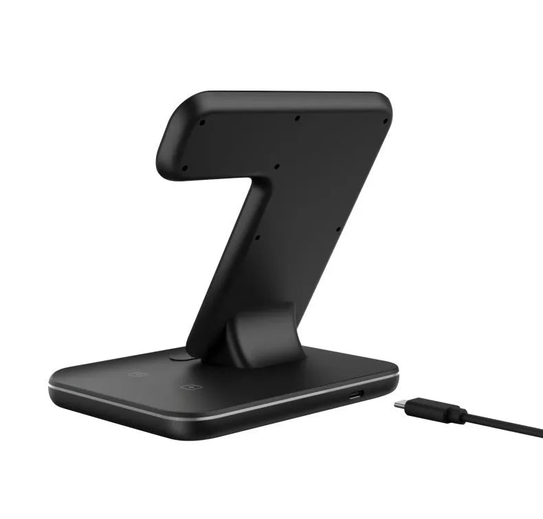 White three-in-one wireless charging stand for mobile phone, smartwatch, and headset on a desk.