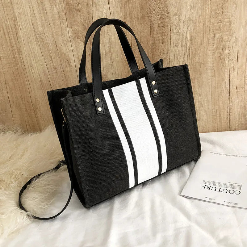 Canvas stripe tote bag in black and white with zipper closure, horizontal square shape, and 120cm shoulder strap