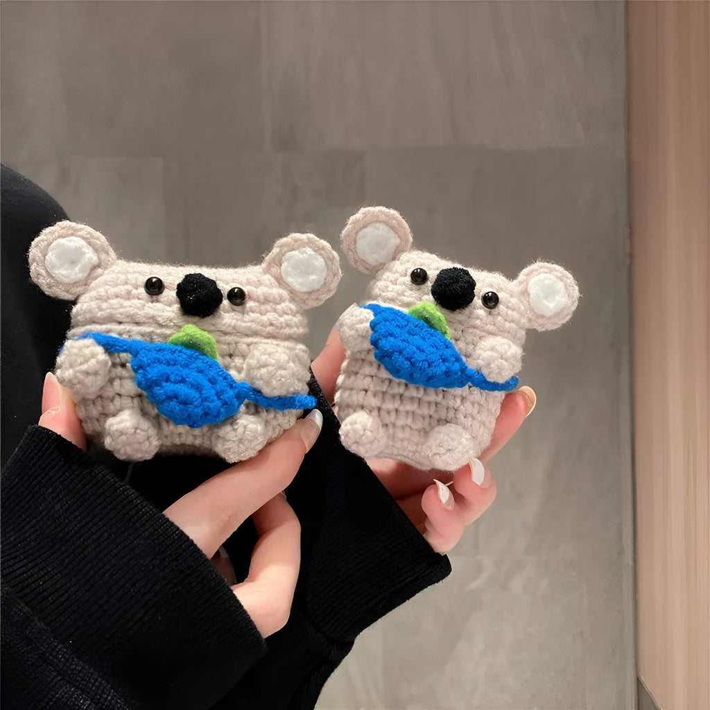 Handmade knitted AirPods case shaped like a backpack with koala ears on a blue background.