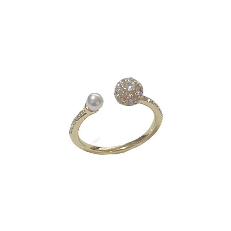 Gold or silver plated open-end pearl ring with round zircon stone on copper base.