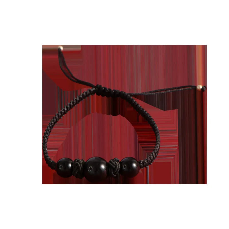 A woven red rope bracelet with a natural strawberry quartz bead and an alloy clasp.