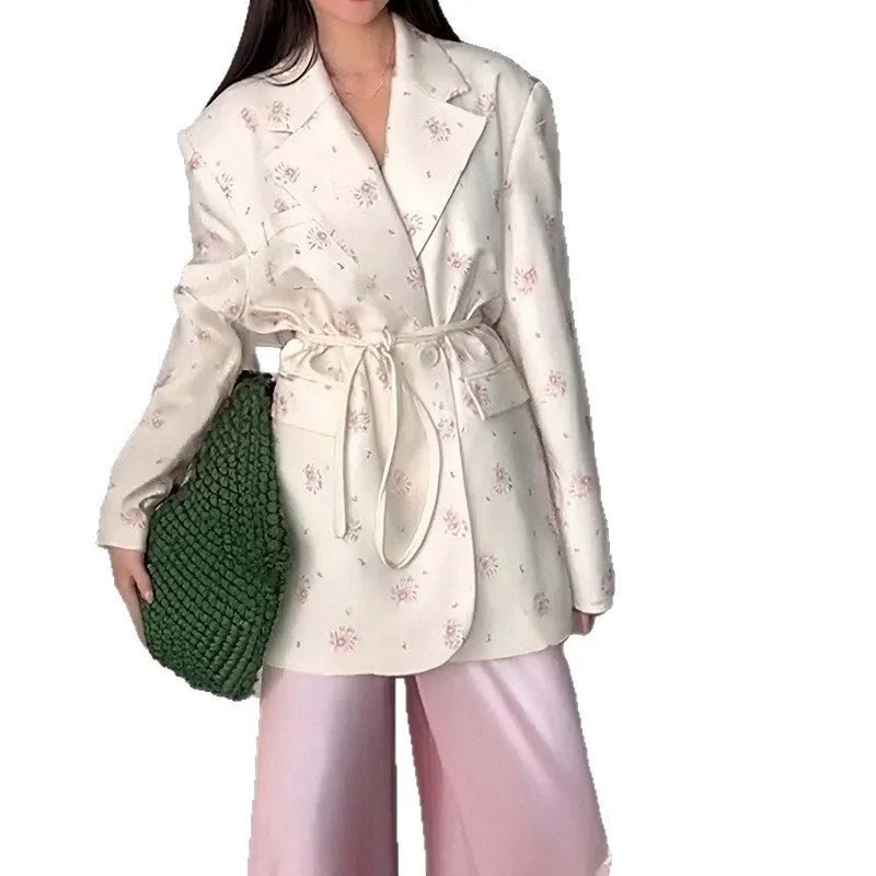 White suit jacket with a lace-up collar and a fitted waist on a model.