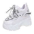 Women's white platform tennis shoes with cross strap and mesh detail on a rubber sole.