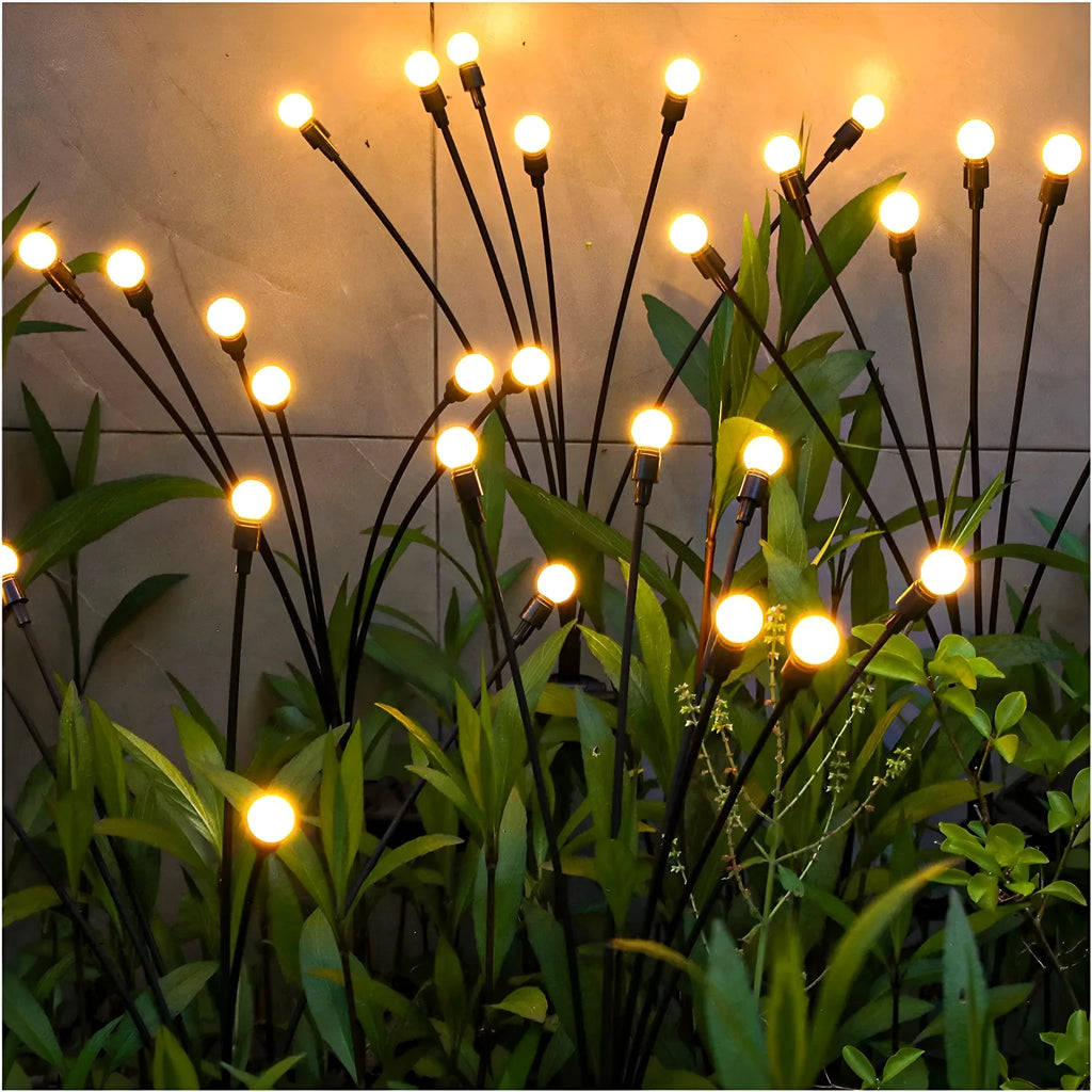 Solar-powered LED garden ground light with multiple light heads and a pneumatic foot pedal for installation.