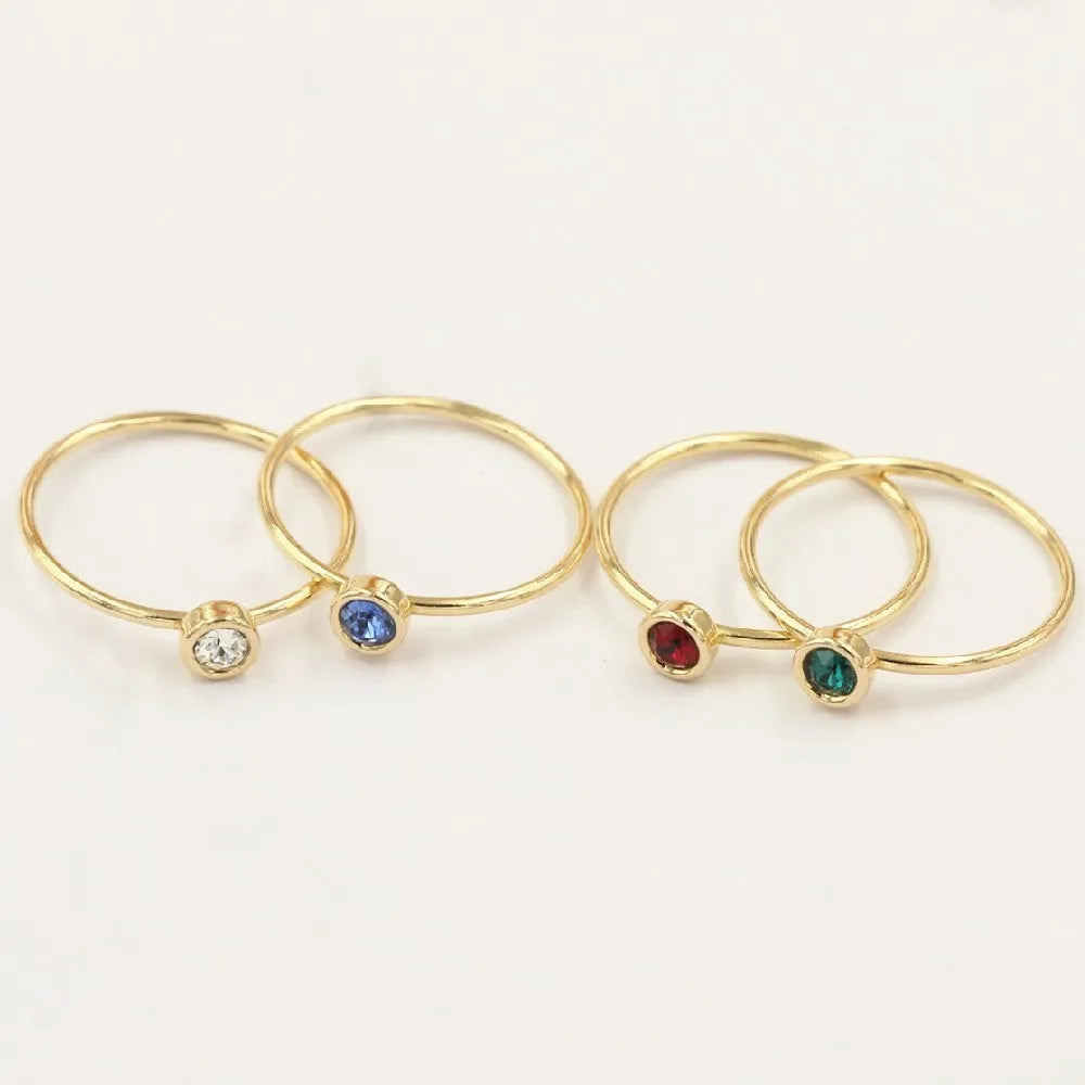 Women's copper knuckle ring with 14K gilding and zircon stones in green, blue, dark red, or white.