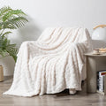 Velvet jacquard sofa throw blanket in a solid colour with woven plant flower pattern, shown in fog blue.