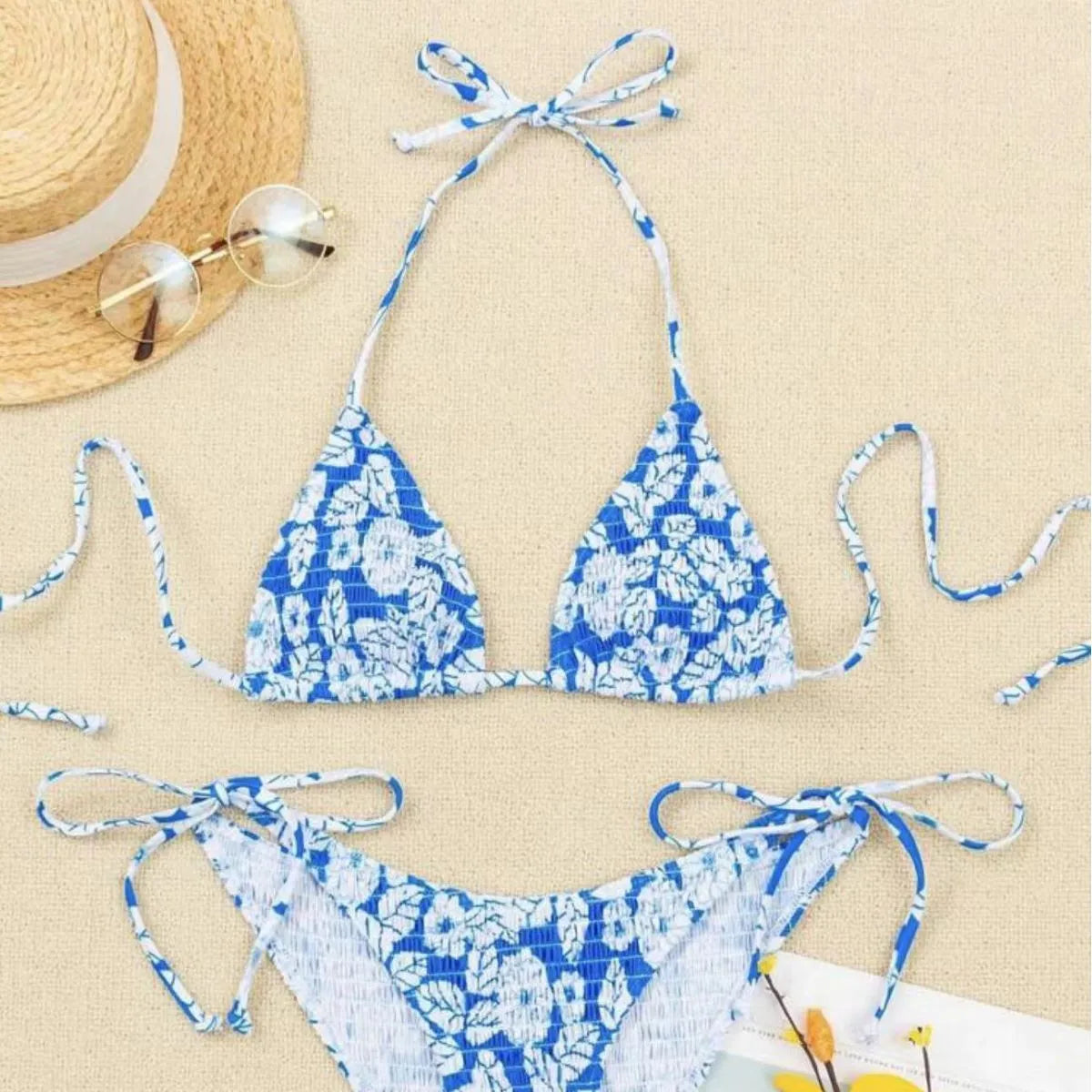 Women's floral print halter swimsuit briefs in light blue on a mannequin.