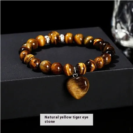 Handmade natural crystal love pendant bracelet with round beads in tiger's eye, aventurine, and white jade on a white background
