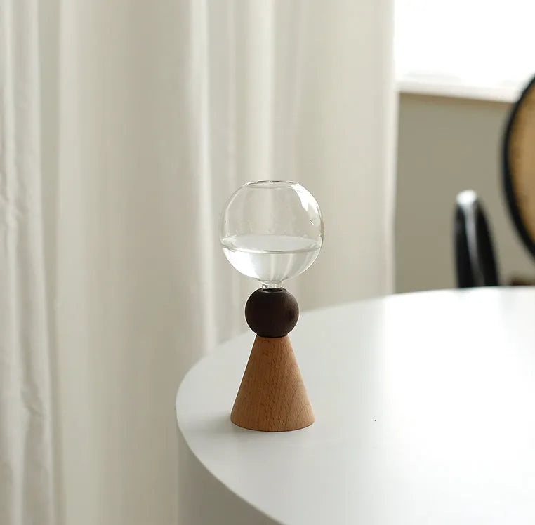 Geometric clear glass bubble vase with wooden base on tabletop with floral arrangement