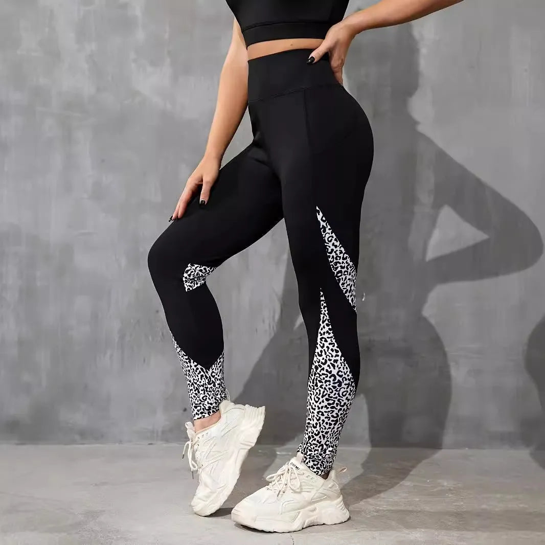 Black women's high-waisted yoga leggings with contrast patchwork design and side pocket.