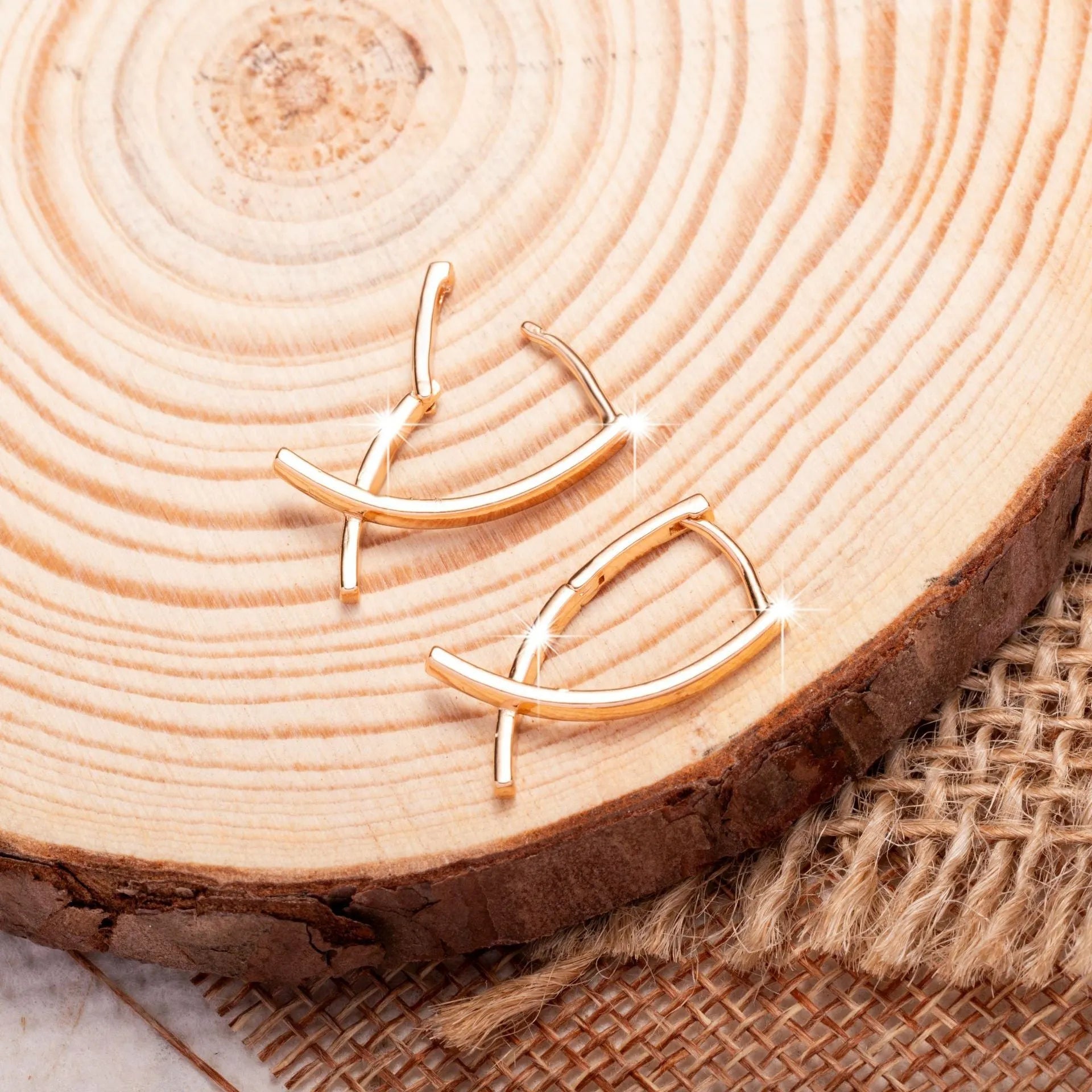Rose gold cross shaped earrings with a polished finish on a solid copper base.