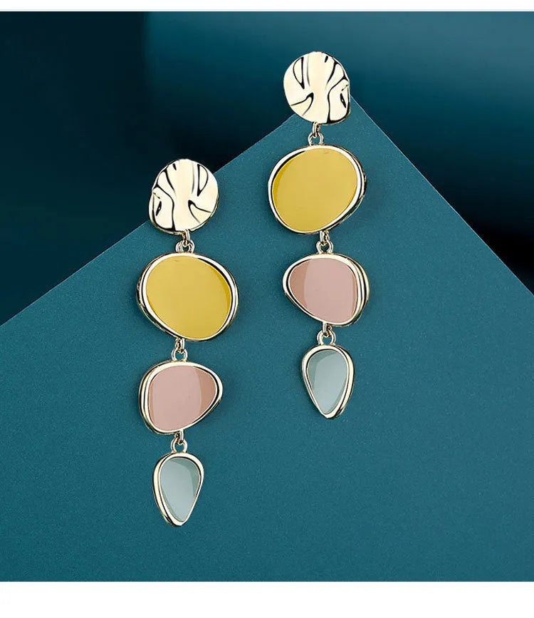 A pair of simple disc-shaped earrings with a morandi three-colour oil-drip finish and sterling silver posts.