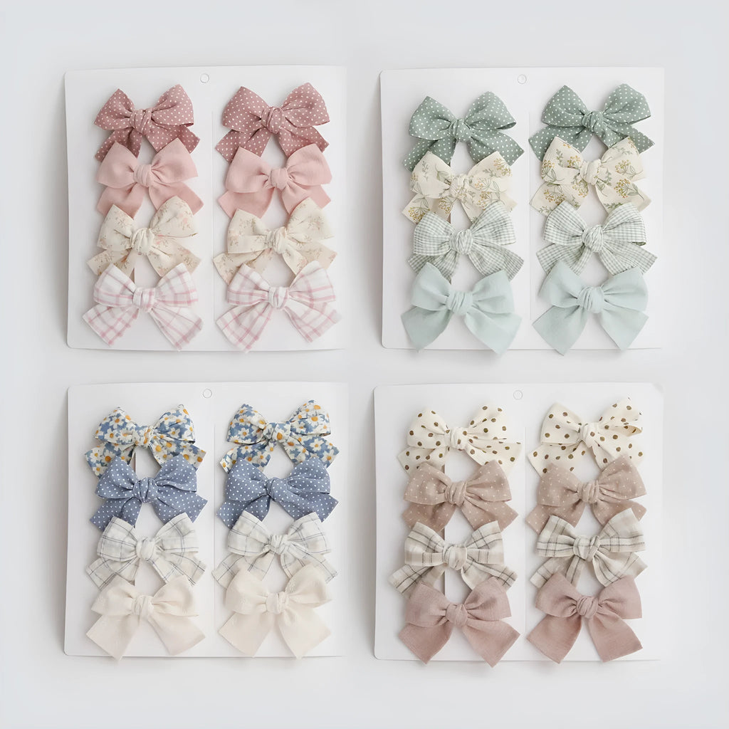 Set of children's cloth hairclips with a dovetail bow design in various colours including beige and blue flowers.