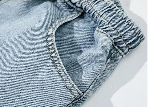 Men's loose cotton sports jeans in retro blue with zipper fly, side view on model