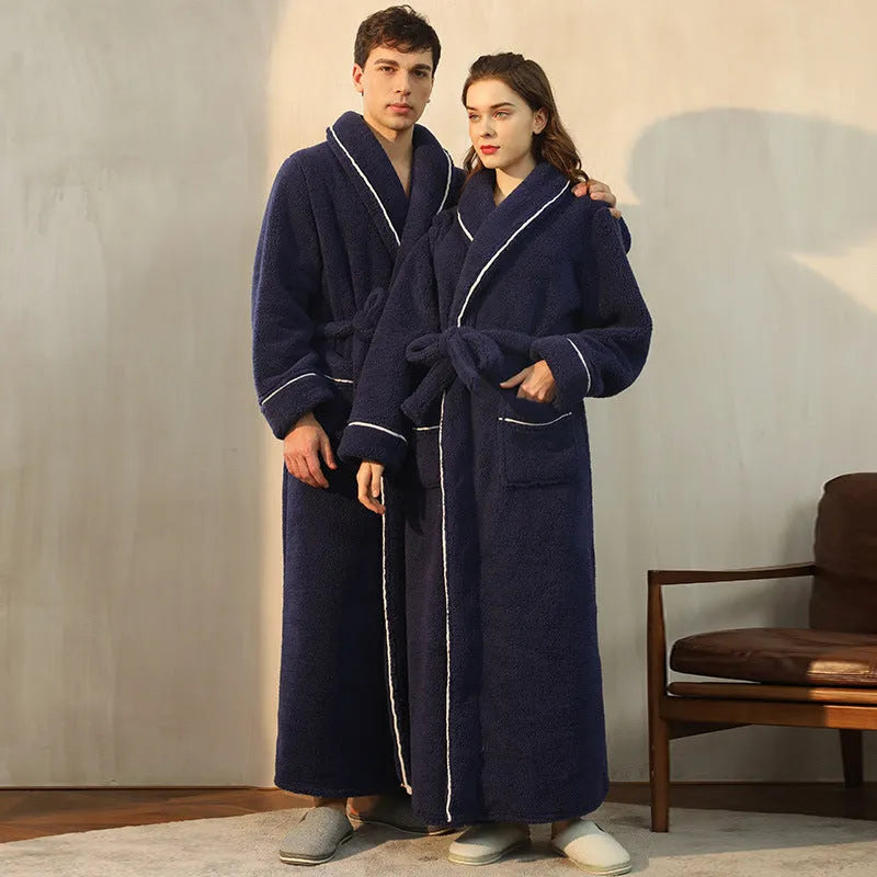 A man and woman wearing matching thick navy blue flannel nightgown robes in a winter home setting.