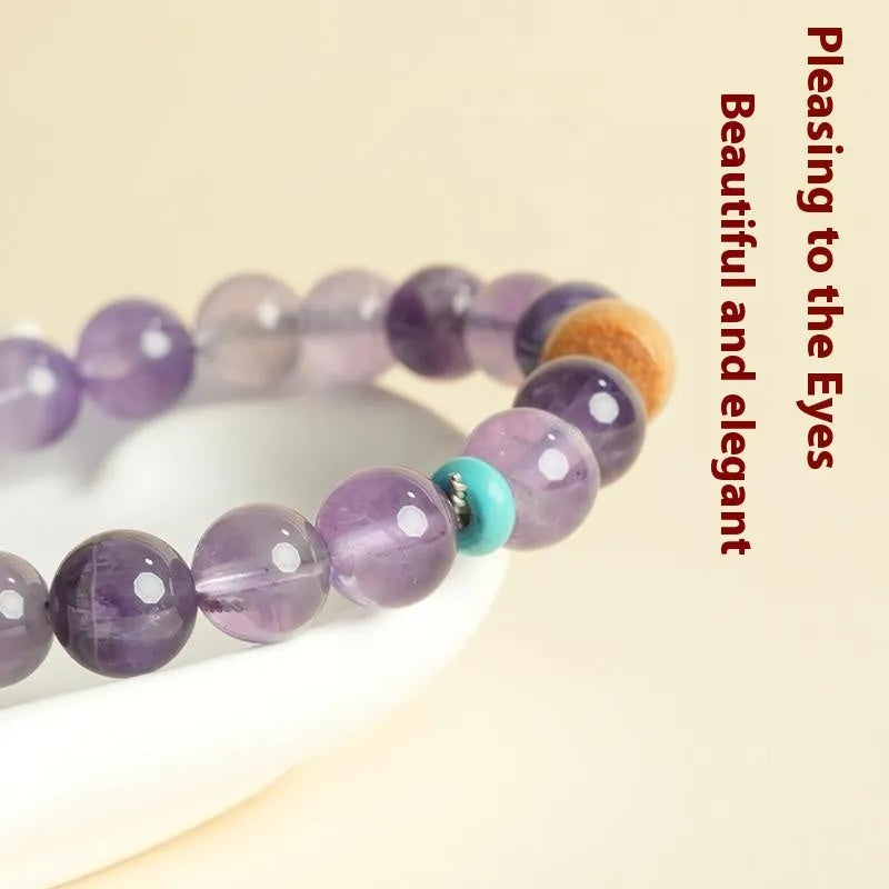 Handmade purple amethyst crystal bracelet for women on a wrist.