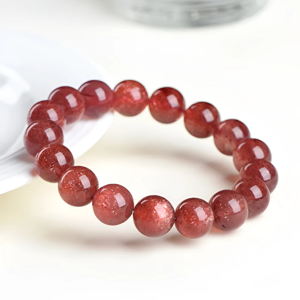 Geometric bead strawberry quartz bracelet in Starlight colour on a wrist, showing size options.