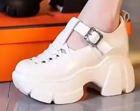 Women's black and white satin pumps with a chunky wedge heel and hollow-out detail.