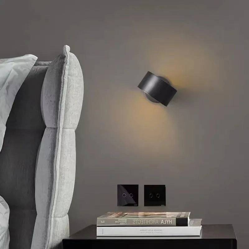 A modern simplistic copper wall lamp shown in a living room setting.
