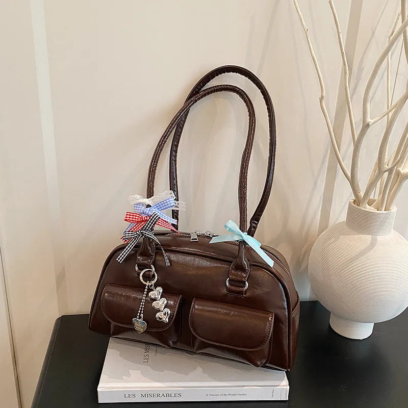 Retro brown PU leather pillow-shaped women's handbag with double straps and a flap closure.