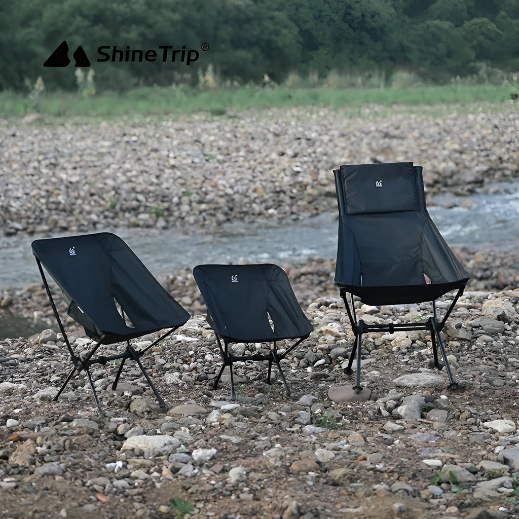 Lightweight aluminium folding moon chair in a garden setting, shown in sand colour with a high back.