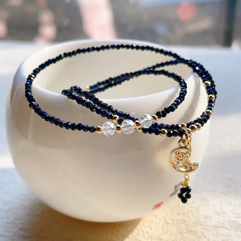 Close-up of a women's multi-layer blue sand bracelet with a three-ring design and gold sand stone cut.