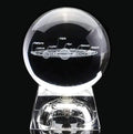 Solar system laser-engraved inside K9 crystal ball on a wooden desk beside an LED base