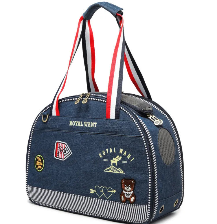 Blue cartoon-patterned denim pet nappy bag with shoulder strap.
