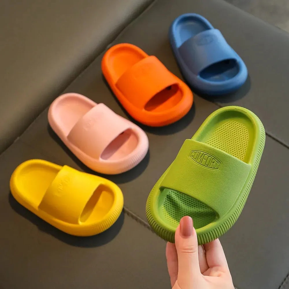 Bright coloured children's EVA slippers with textured sole, shown in blue, green, orange, pink, and yellow.