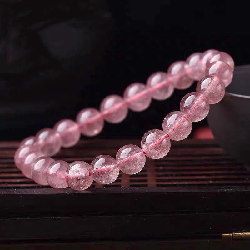 Women's strawberry quartz crystal bracelet with polished beads in 6mm, 8mm, or 10mm diameter options