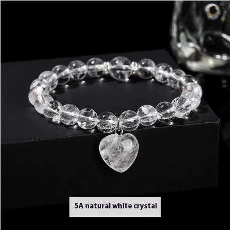 Handmade natural crystal love pendant bracelet with round beads in tiger's eye, aventurine, and white jade on a white background