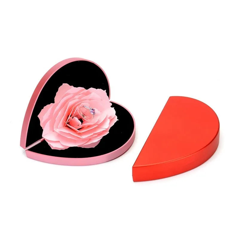 Red rotating 3D heart-shaped plastic ring box with a rose, open to show ring placement.
