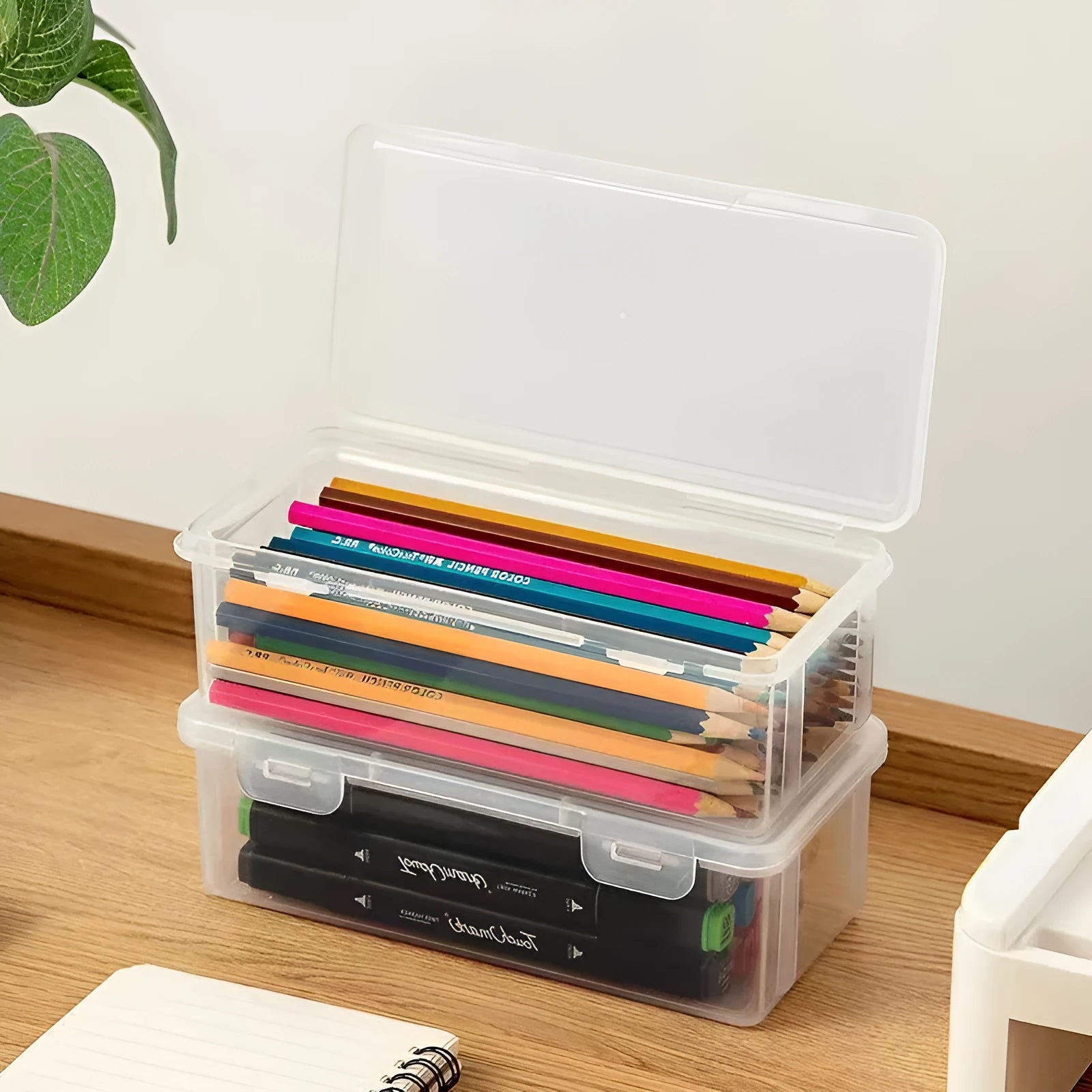 Transparent pencil storage box showing organised stationery including pencils and art supplies