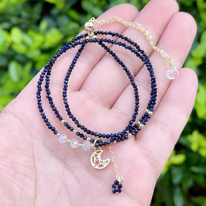 Close-up of a women's multi-layer blue sand bracelet with a three-ring design and gold sand stone cut.