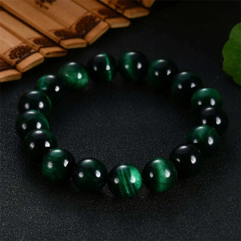 Green Tiger Eye stone bracelet with round polished beads on a wrist.