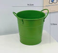 Round metal pen holder in a choice of colours, some with decorative sticker patches, on a wooden desk.