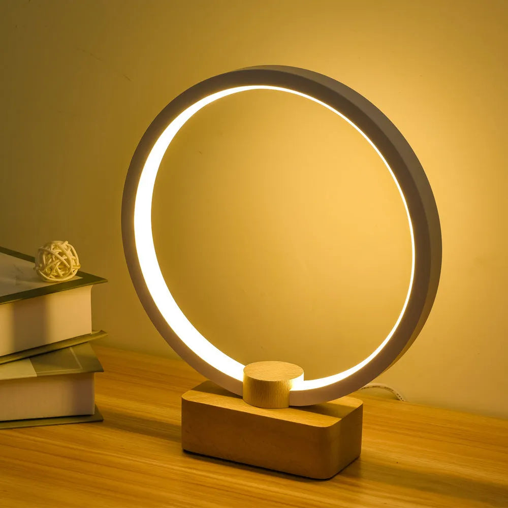 Round small solid wood and bamboo USB-powered LED night lamp on a table.