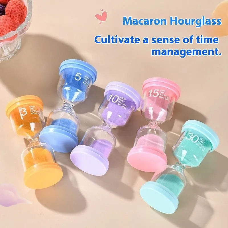 A glass hourglass sand timer on a desk, showing purple sand flowing between bulbs.