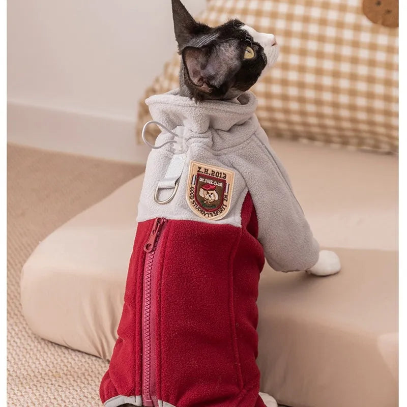 Four-legged fleece jacket for cats and small dogs in colour block design with badge patch, showing front zipper and elastic cuffs.