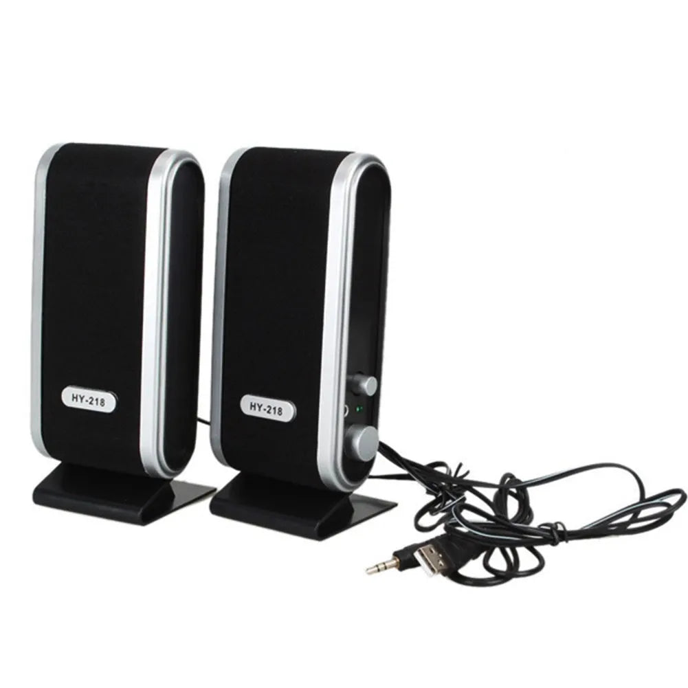 A black notebook mini speaker with a USB cable for computer audio.
