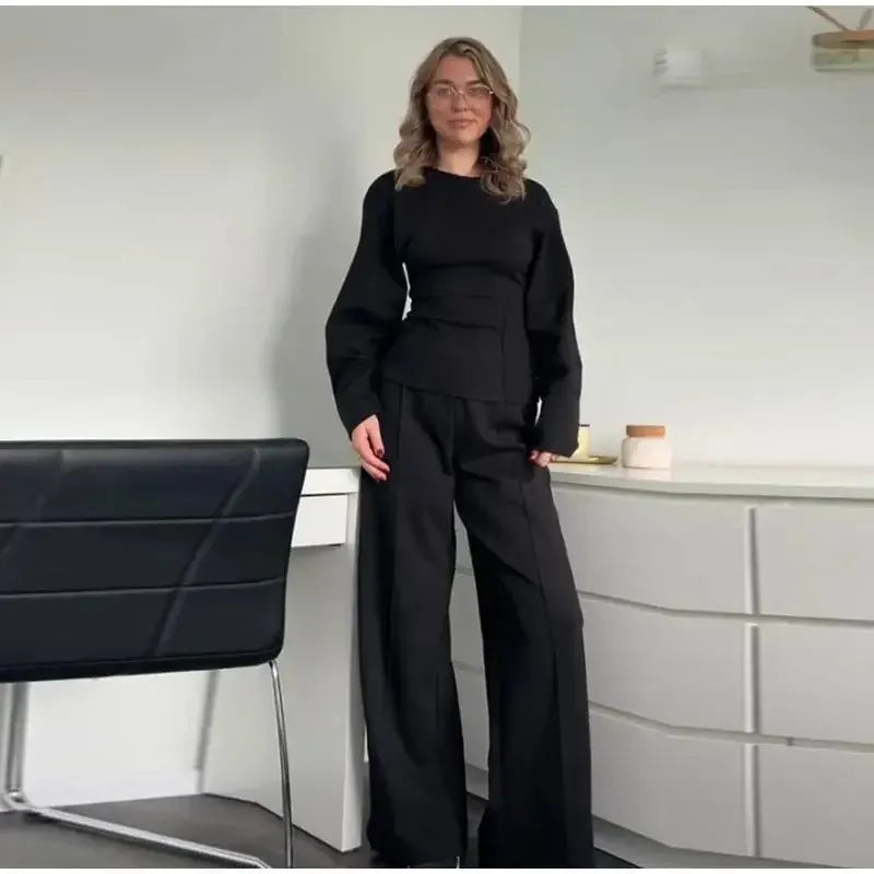 Women's black polyester fleece two-piece suit with long sleeve top and wide-leg trousers on a hanger.