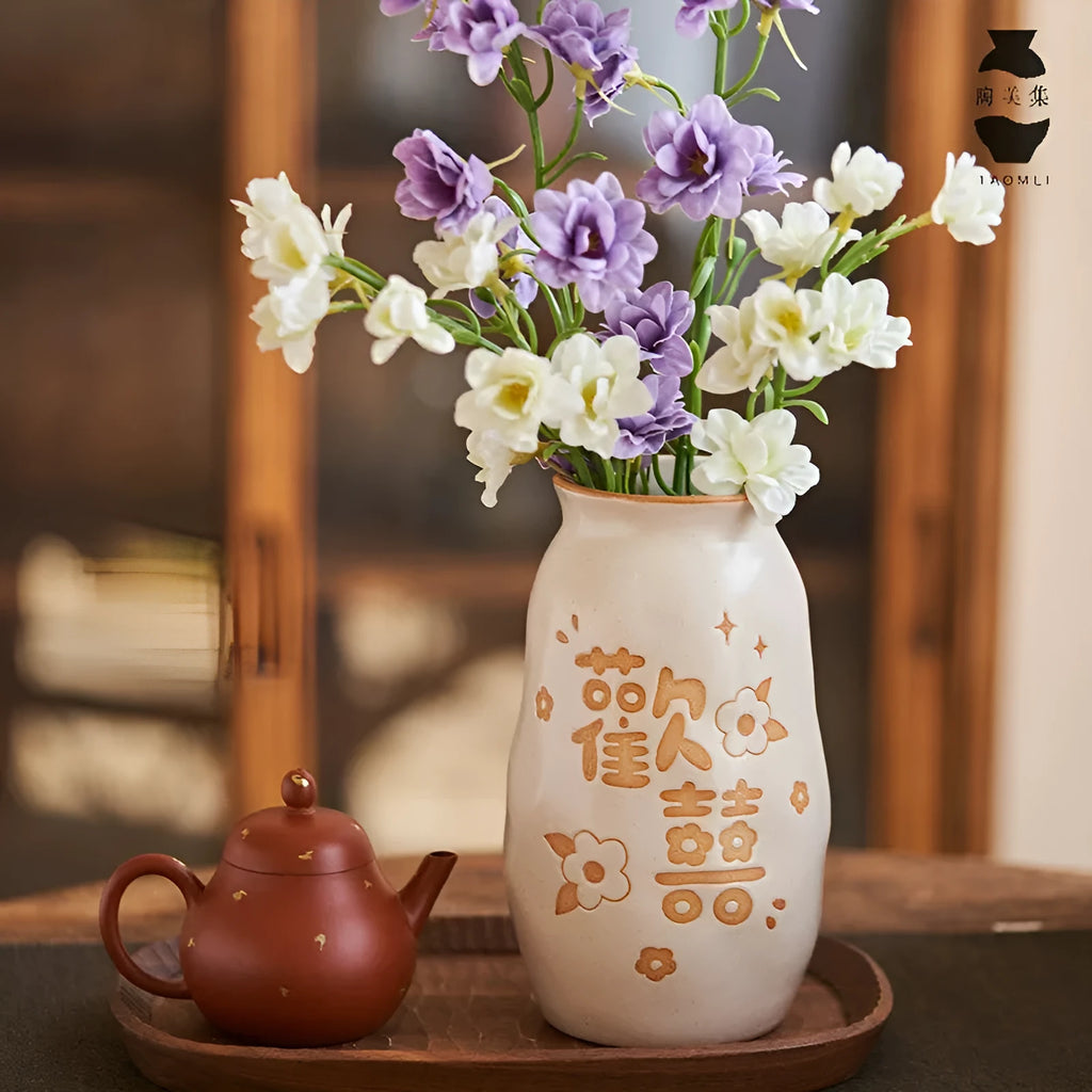 Chinese hand-painted ceramic vase with carved design on wooden desk