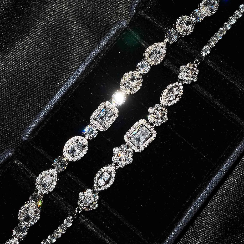 Women's geometric silver bracelet with inlaid white zircon stones on a wrist, showing adjustable clasp.