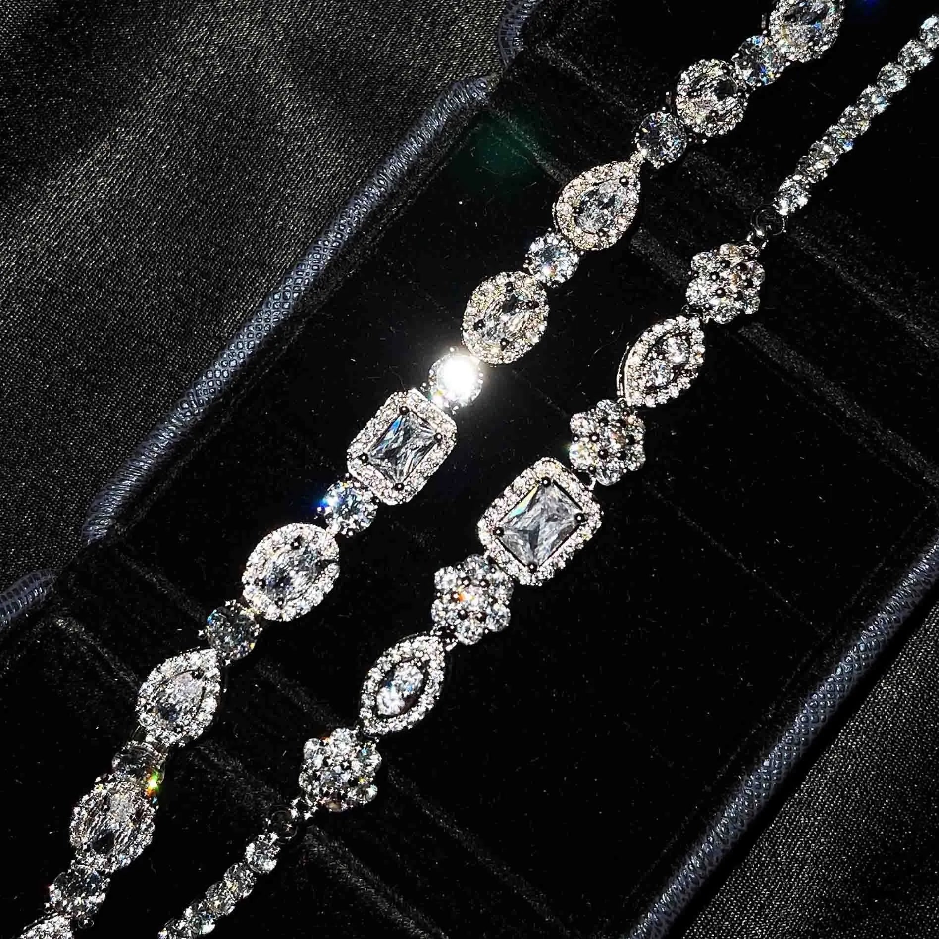 Women's geometric silver bracelet with inlaid white zircon stones on a wrist, showing adjustable clasp.