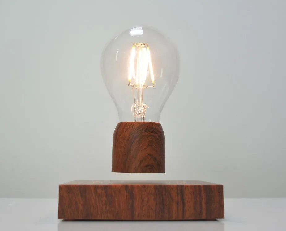 Magnetic levitation floating light bulb hovering above an imitation wood base.