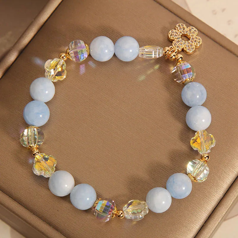 Women's aquamarine crystal bracelet with four-leaf clover design and a pearl accent.