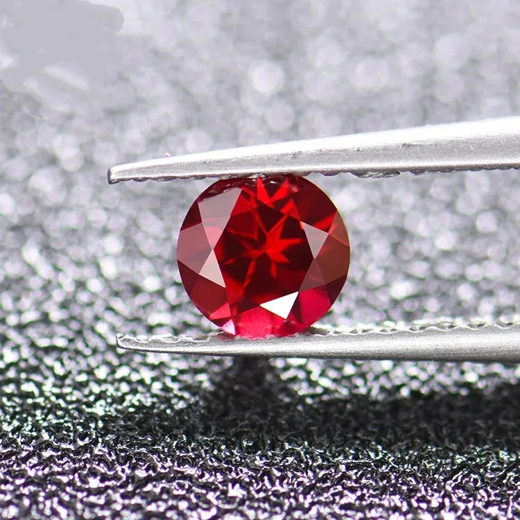 A loose, faceted cultured ruby gemstone in a pigeon blood red colour on a white background.