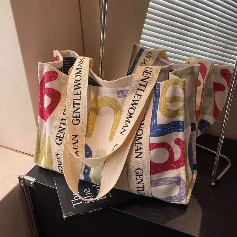 Large women's canvas tote bag with printed design, shown in available colour options.